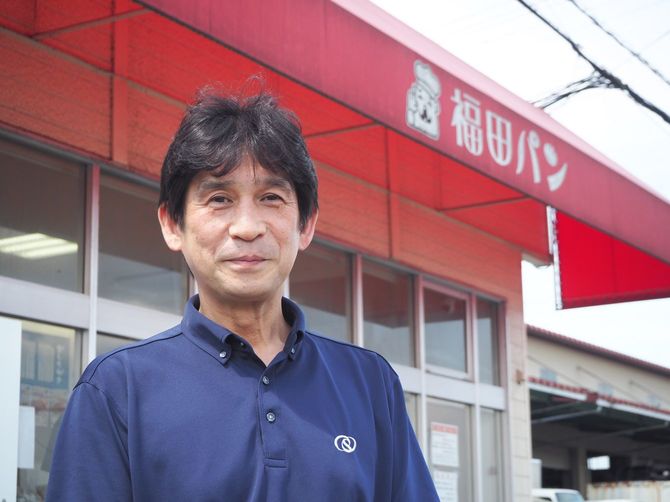 福田パン矢巾店の前にたつ3代目社長・福田潔さん