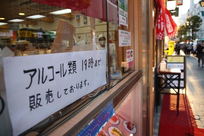 まん延防止等重点措置が始まり、店頭に掲げられた午後7時までの酒類提供を知らせる張り紙＝2021年6月21日、東京都港区