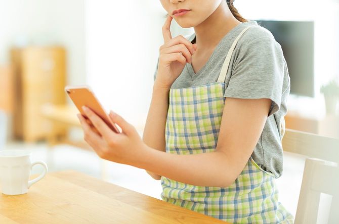 スマートフォンを操作する主婦
