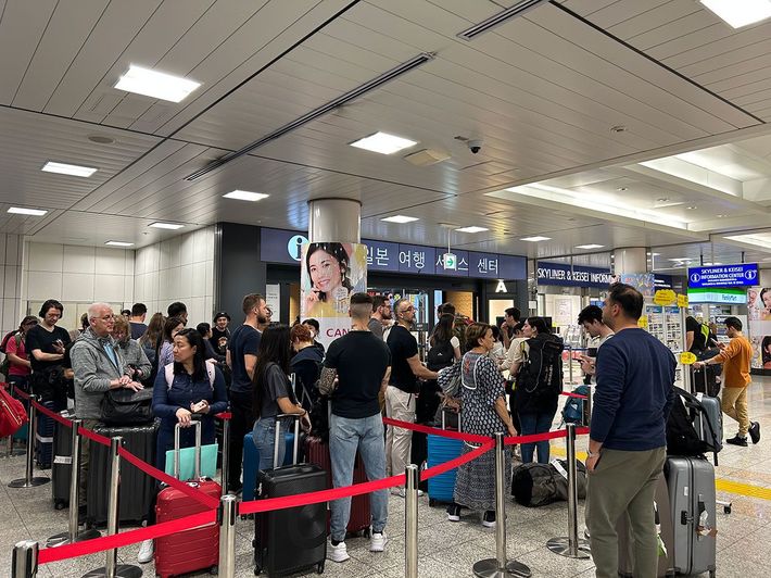 「ジャパン・レール・パス」の購入のために並ぶ外国人旅行客