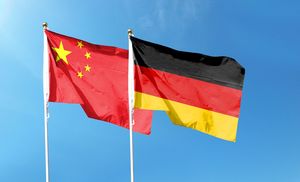 青空にたなびくドイツ国旗と五星紅旗
