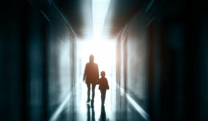 光の中を歩く母と息子