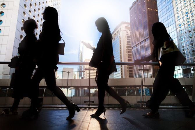 香港中央地区の高架歩道を歩くビジネスウーマンのシルエット