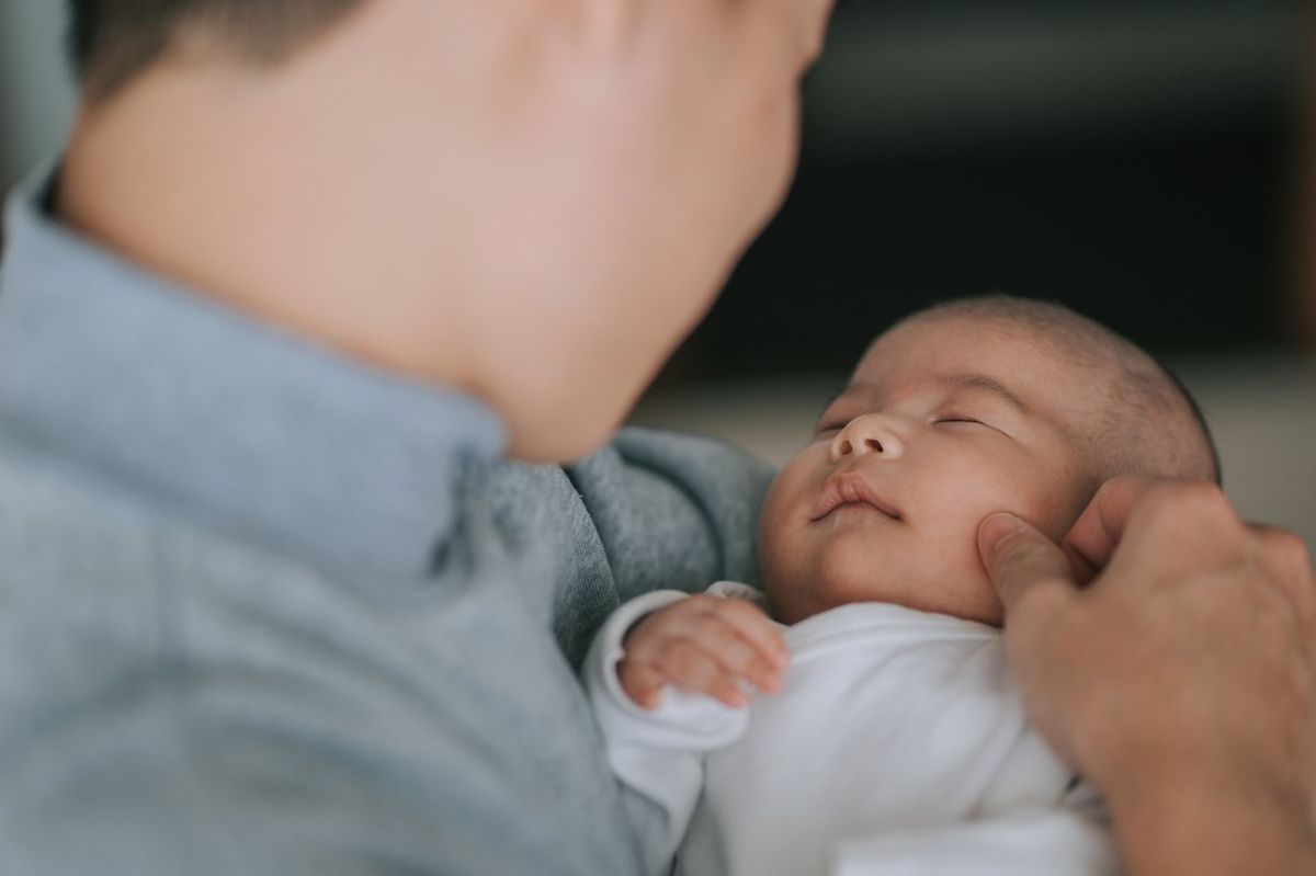 新生児を抱っこする父親