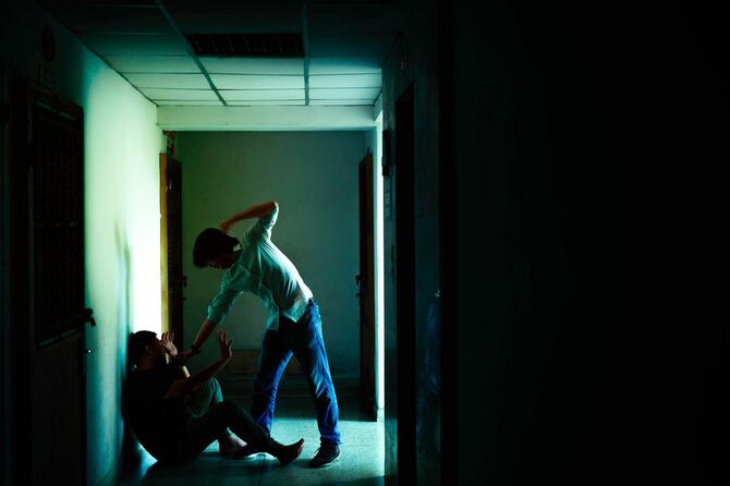 暗い廊下で男を殴りつける男