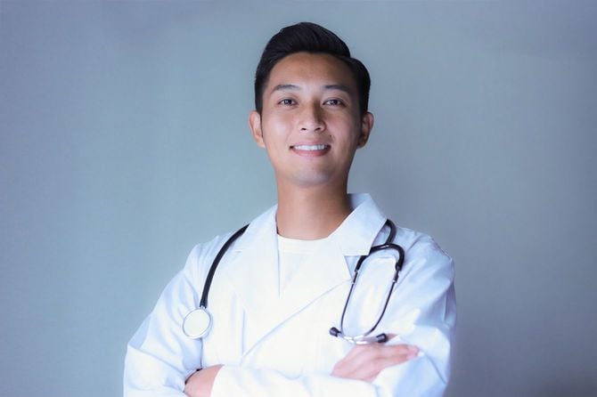 カメラに向かってポーズをとる若い医師