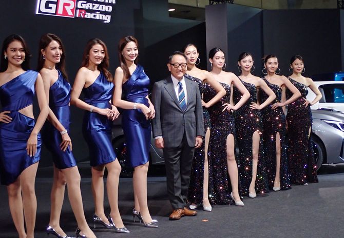 東京オートサロンの会場で撮影に応じるトヨタ自動車の豊田章男会長（中央）＝2024年1月12日、千葉市の幕張メッセ