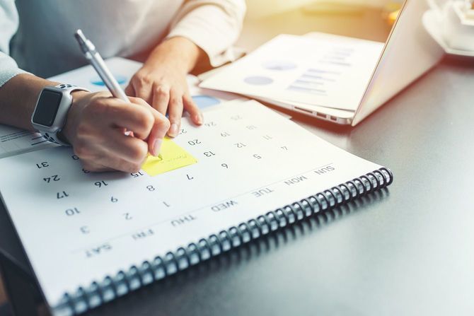 カレンダーを見ながらメモをする人