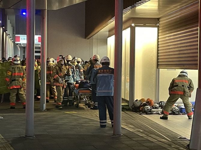 走行中の電車内で乗客が刺傷されるなどした事件で、大勢の消防隊員や救急隊員らで騒然とする京王線国領駅前=2021年10月31日、東京都調布市