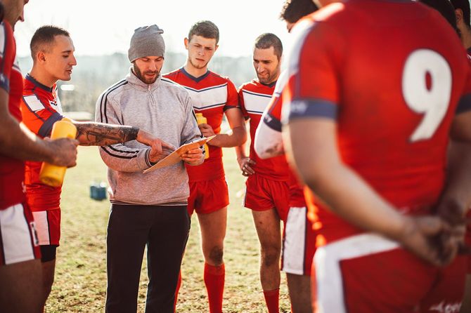 タイムアウト中に選手のグループと話すコーチ