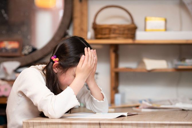 勉強中、頭を抱える子供