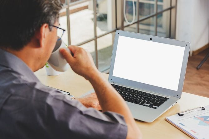 ラップトップを開いているシニア男性