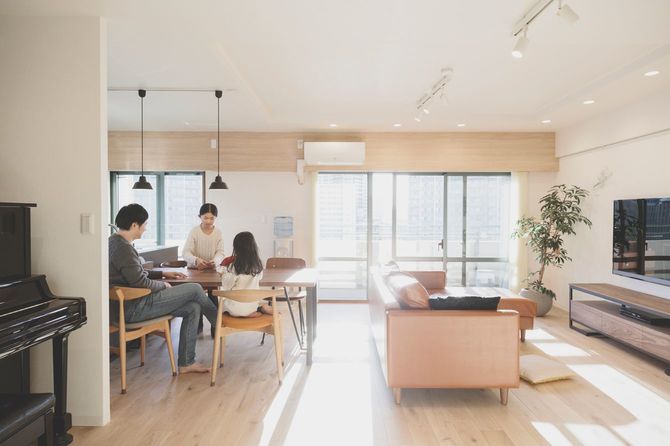 広々としたリビングルームで親子3人がトランプで遊んでいる