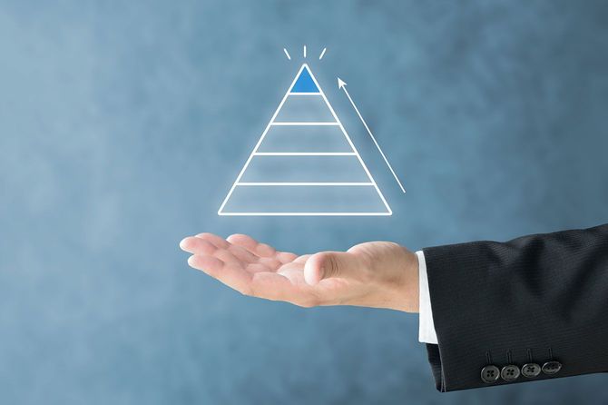ビジネスマンの手の上にあるピラミッド型の図形