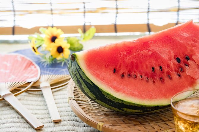 カットされたスイカとうちわ