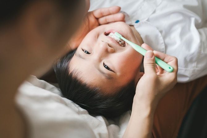 息子の歯を磨く母親