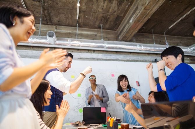 オフィスでビジネスの成功を祝っているグループ