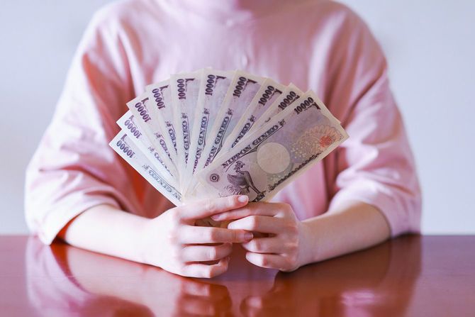 札束を持つ女性