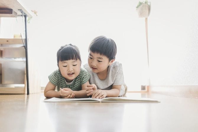 家で本を読むきょうだい