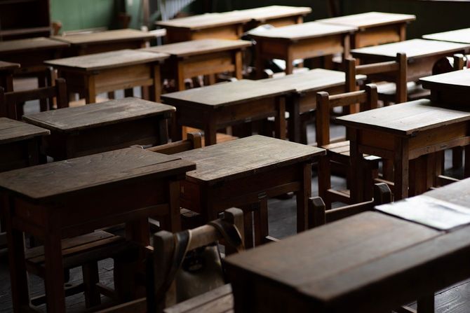 古い机と椅子が並ぶ学校の教室