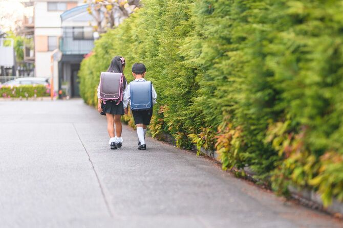 手をつないで歩く日本の小学生のきょうだい