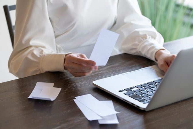 領収書を見て会計をする若い女性の手