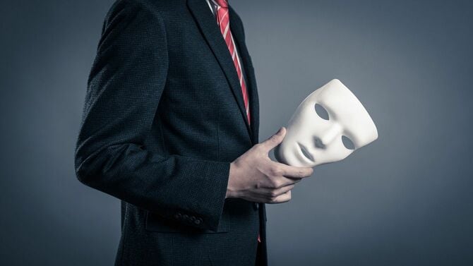 仮面を手にしたビジネスマン