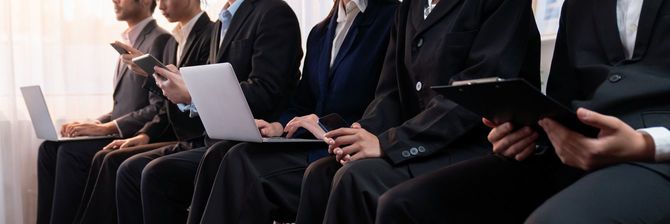 面接のために待合室に座る求職者たちの列