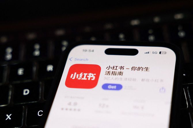 2025年1月15日、ポーランドのクラクフで撮影されたこの写真には、ノートパソコンのキーボードと、スマートフォンの画面に表示されたApp Storeの「RedNote」が写っている